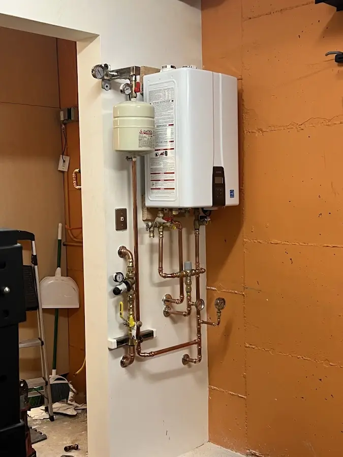Plumbing technician inspecting water heater connections in Morganfield